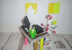 Kaja "Stokrotki" Plastelinowa figurka siedzi za biurkiem